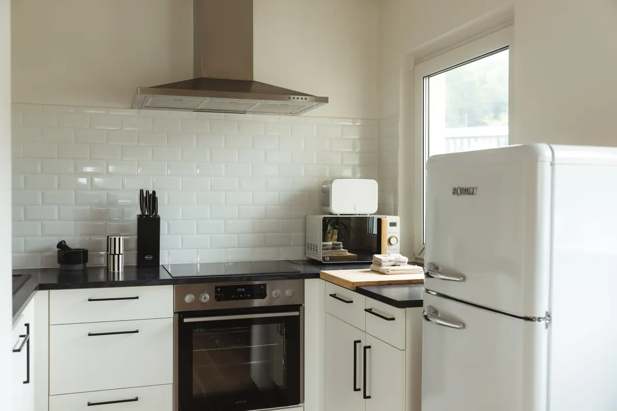Fully equipped white kitchen with oven and refrigerator